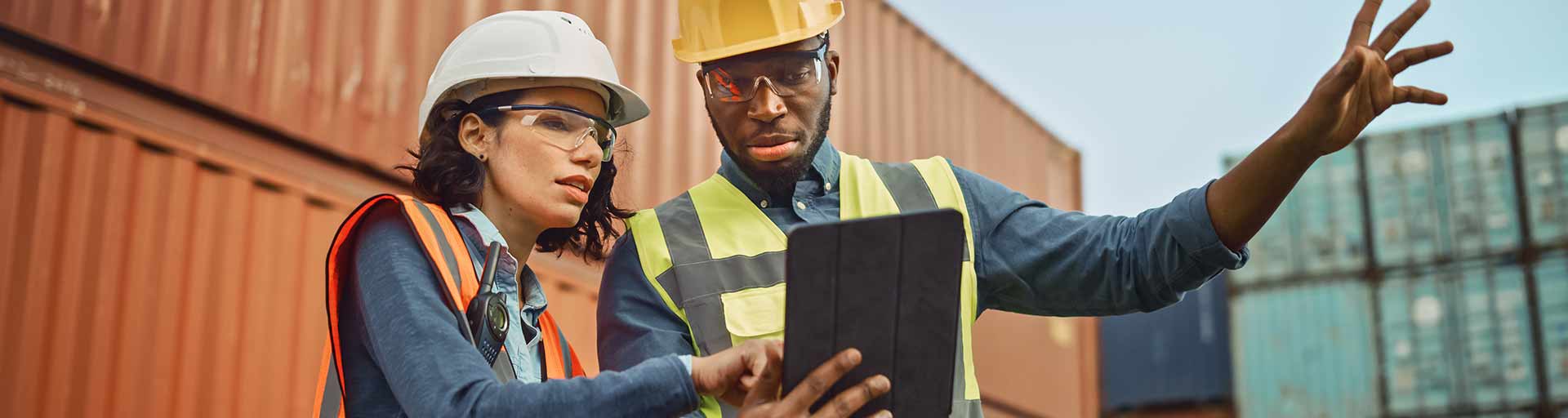 Two people looking to tablet in a worksite