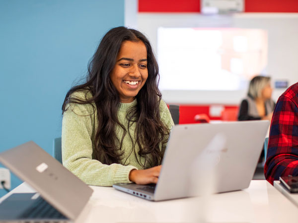 smiling student using a laptop