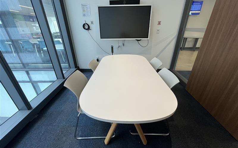 Small meeting room with table, chairs & screen